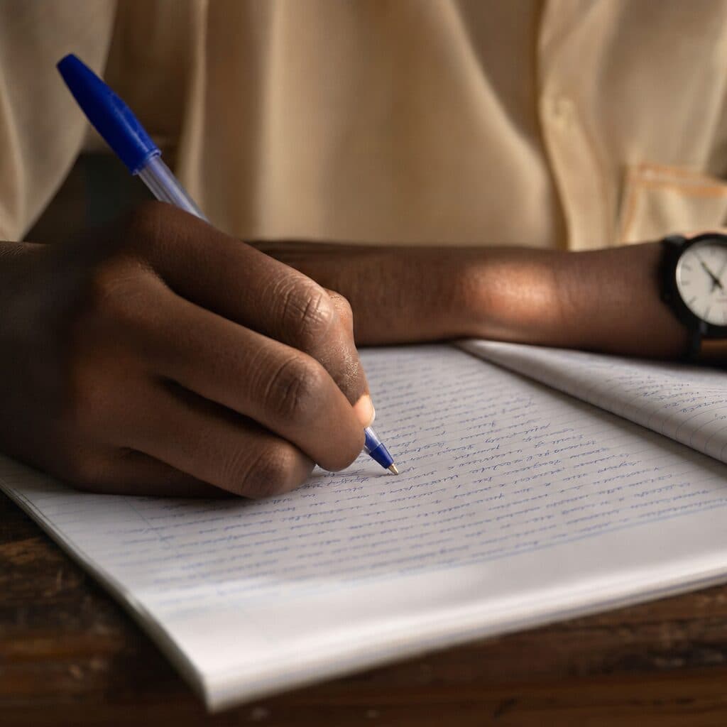 Hands writing in an exercise book